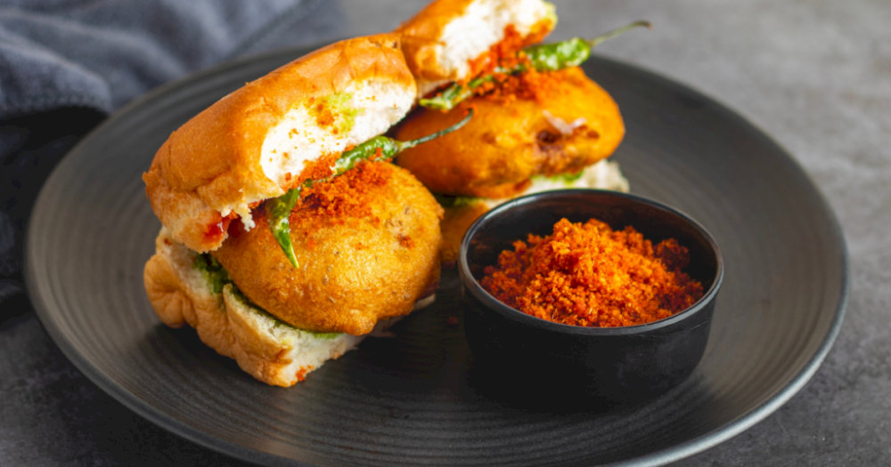 Vada Pav is typically eaten as a quick snack or breakfast on the go